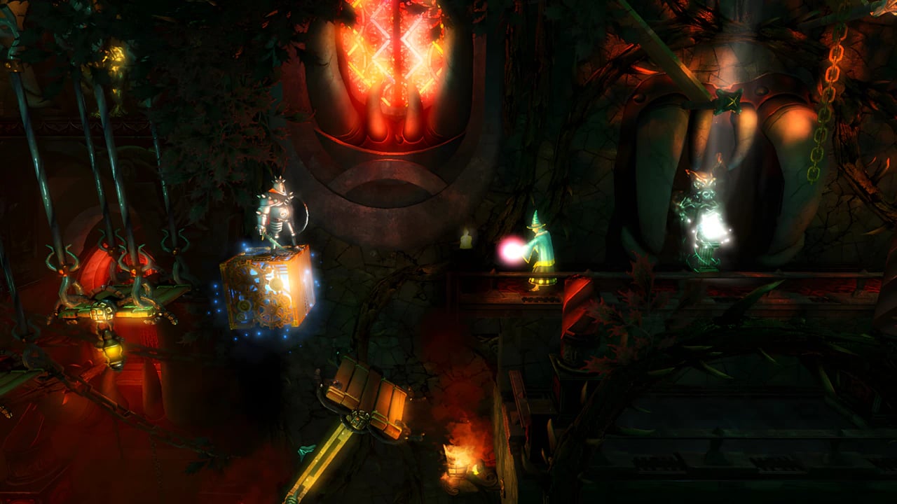 Trine - Cave Puzzle Solving A gameplay scene from the game Trine showcasing the three heroes in a dark cave level with puzzle elements. Pontius, the knight, stands on a floating cubic block on the left; Amadeus, the wizard, is in the center with a green glow; and Zoya, the thief, is on the right on a platform. The environment includes machinery, chains, and glowing lights in orange and green tones.
