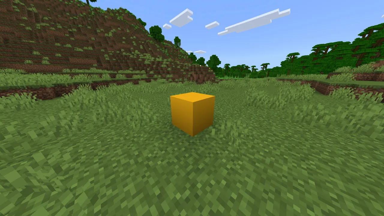 A yellow cube sits prominently in a vibrant green, blocky landscape, reminiscent of Minecraft, under a blue sky with clouds.