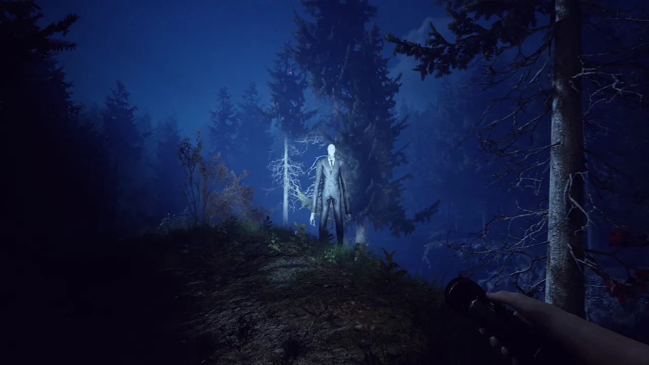 Screenshot from a horror game, featuring Slender Man in a dark, misty forest at night. First-person view with a flashlight adds tension.